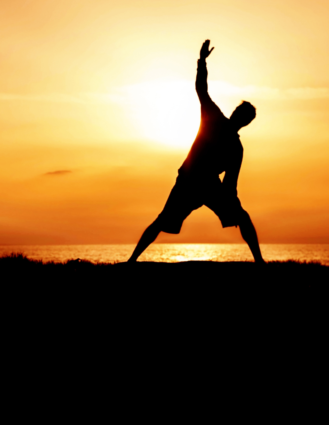 Silhouette of a man doing yoga
